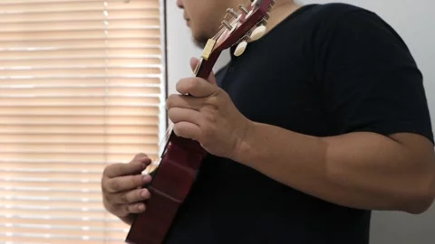 Asian man singing while playing ukulele Video stock 293534415