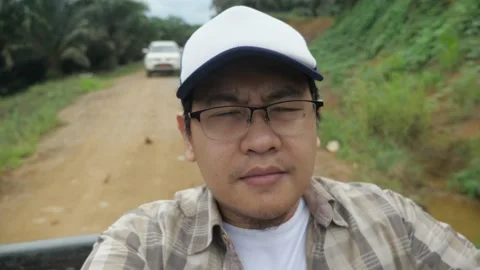 Asian man sitting in the back of pickup truck, outdoor safari trip adventure  Stock Footage 150563531