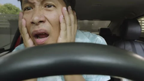 Asian man sitting in car while scared by seeing something. Stock Footage 236843455