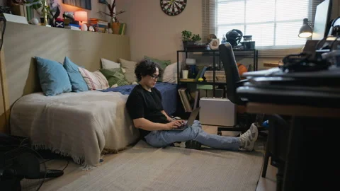 Asian Man Sitting on Floor Using Laptop for Remote Work Stock Footage 338422070