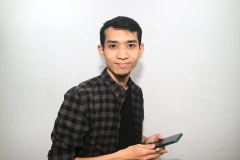 Asian man smiling happy while holding mobile phone Stock Photos