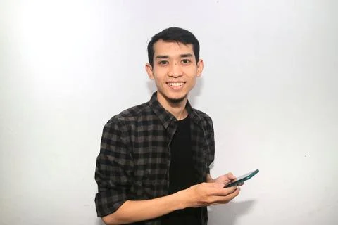 Asian man smiling happy while holding mobile phone Stock Photos