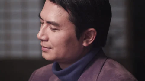 Asian man smiling &amp; turning to camera slow motion closeup Stock Footage 30477507