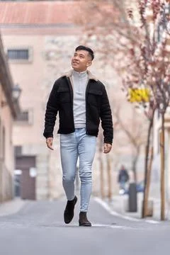 Asian man smiling while walking outdoors on the street. Foto stock