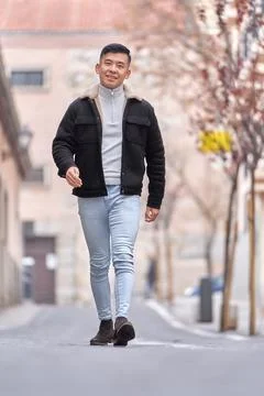 Asian man smiling while walking outdoors on the street. 스톡 사진