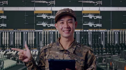 Asian Man Soldier Using A Tablet And Pointing To Side In Military Armory Stock Footage 313740223