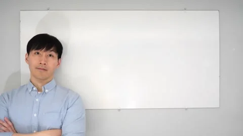 Asian man standing in front of a white board writing yes no or mabye Vidéo 263858652