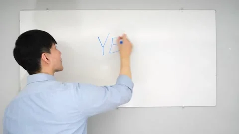 Asian man standing in front of a white board writing yes no or mabye Vidéo 263858682