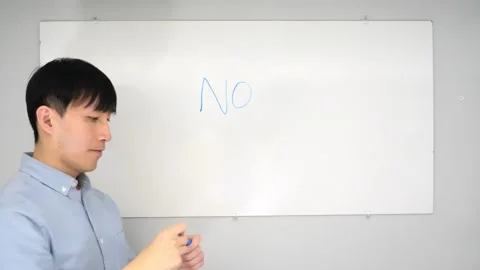 Asian man standing in front of a white board writing yes no or mabye Vidéo 263858724
