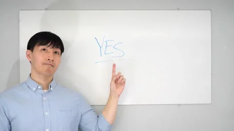 Asian man standing in front of a white board writing yes no or mabye Vidéo 263858733
