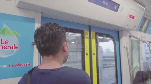 An asian man is standing inside the mrt. Stock Footage 222033349