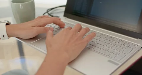 Asian man starting task, typing steadily on silver laptop at home office desk Stock Footage 335836253