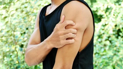 Asian man suffering from upper arm pain while exercising outdoors. Stock Footage 265926695