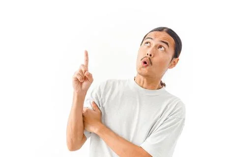 An Asian man with a surprised expression looking and pointing upwards at em.. Stock Photos