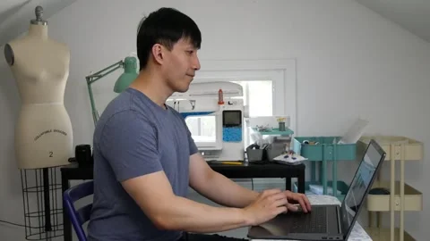 Asian man taking a stretch break while working on his laptop Stock Footage 247874265