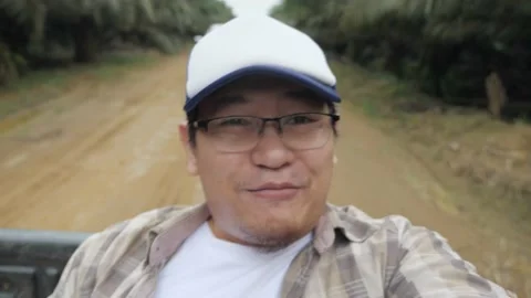 Asian man talking to camera while ride on a open truck in the rural area di.. Stock Footage 233548288