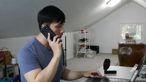 Asian man talking on his cell phone frustrated about his work Stock Footage 247917968