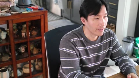 Asian Man talking to someone with camera off center Stock-Footage 318189601