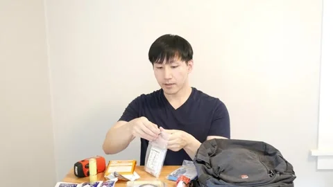 Asian man talking toward the camera about an emergency blanket in a safety Stock Footage 248869070