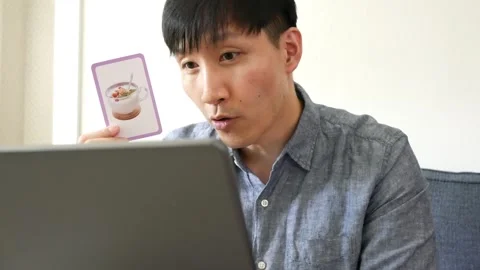 Asian man teaching an online class with yogurt flash card Stock Footage 247479999