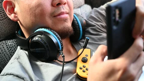 Asian man texting and web browsing on his cell phone Stock Footage 147742274