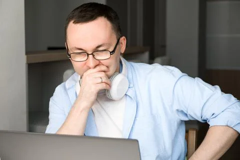 Asian man thinking over some decision or proble, looking at laptop screen.Wor Stock Photos