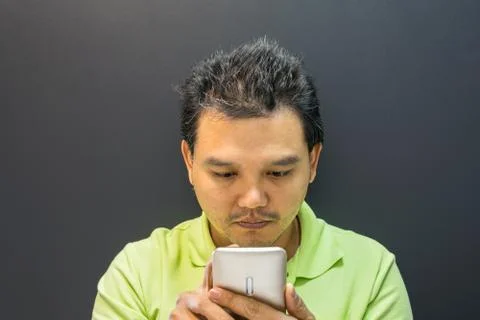 Asian man thinking using smartphone in dark style Foto stock