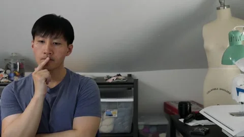 Asian man thinking while  pointing his fingers to his lips Stock-Footage 247874298