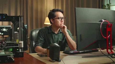 Asian Man Thinking While Works On Personal Computer And 3D Printer In Home Stock Footage 158108092