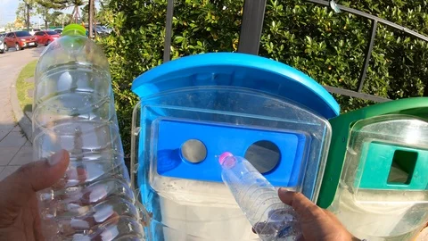 Asian man throwing plastic bottle into blue trash can. Video stock 97457579