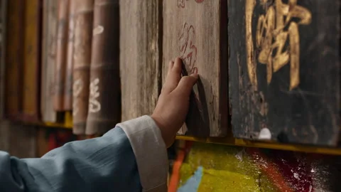 Asian man touching ancient scrolls with a calm and contemplative expression Stock Footage 306654397