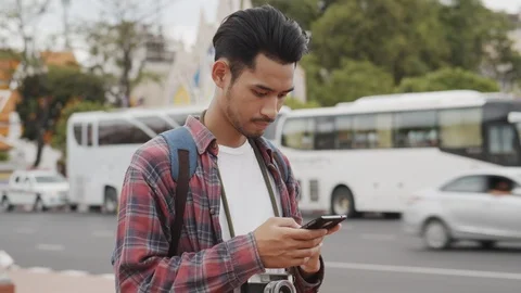 Asian  man tourist using  smart phone at Tourist attraction Roadside Stock Footage 118836343