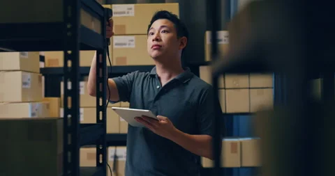 Asian man use barcode scanner scan paper box and put data in digital tablet. Stock Footage 202131518