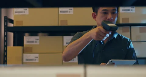 Asian man use barcode scanner scan paper box in shelf and put digital tablet. Stock Footage 203411422