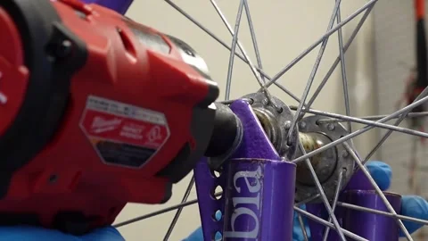 Asian man uses tools to fix wheel of a bike San Francisco CA USA July 15 2025 Stock Footage 313171610