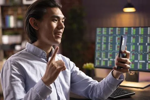 Asian man using cellphone for virtual meeting with clients Foto stock