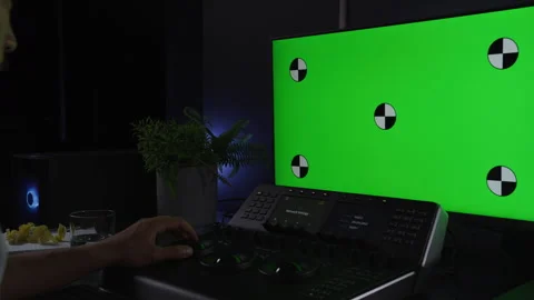 Asian man using color grading tools and a big green screen Stock Footage 264222932