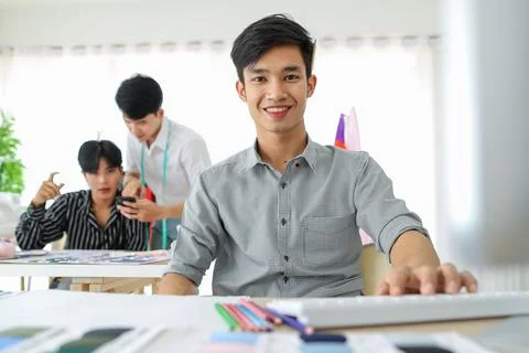 Asian man using computer near colleagues in atelier Stock Photos