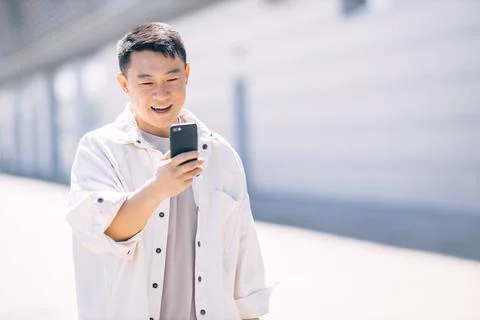 Asian man using a digital device to talk to friends Stock Photos
