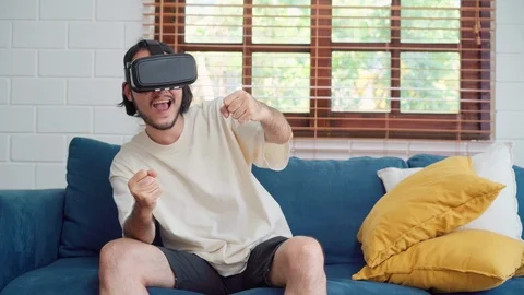 Asian man using glasses virtual reality simulator playing video games. Stock Footage 109413374