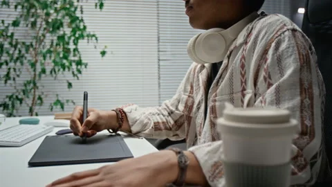 Asian Man Using Graphics Tablet for Digital Design in Office Stock Footage 348345116