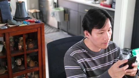 Asian Man using his cell phone camera off center Stock Footage 318189602