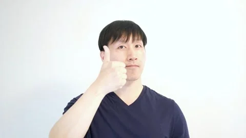 Asian man using his right hand giving the thumbs up with a nod Stock Footage 248869510