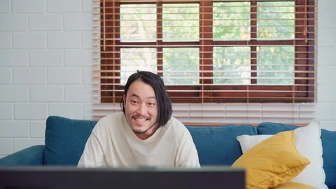 Asian man using joystick playing video games in television in living room. Stock Footage 109411928
