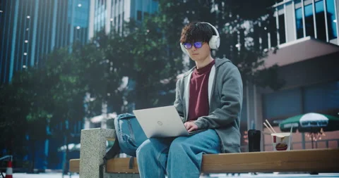 Asian Man Using Laptop Computer on City Street Stock Footage 295811097