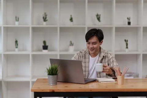 Asian man using laptop computer working at office. Creative and new idea concpet Stock Photos
