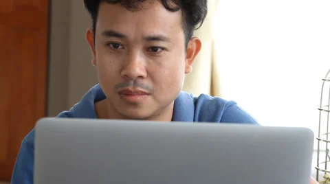 Asian man using laptop in living room 库存影片 54101159