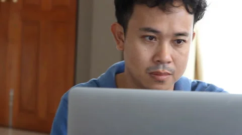 Asian man using laptop in living room Stock Footage 54101442