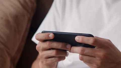 Asian man using mobile phone playing video games in television in living room. Stock Footage 113135848