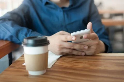 Asian man using phone in coffee shop Stock Photos